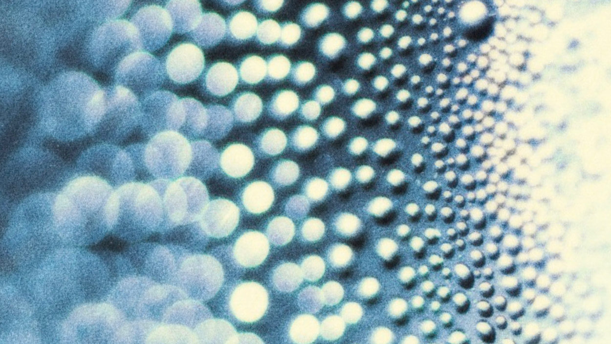 Abstract blue pattern of glowing circular lights and blurred dots.