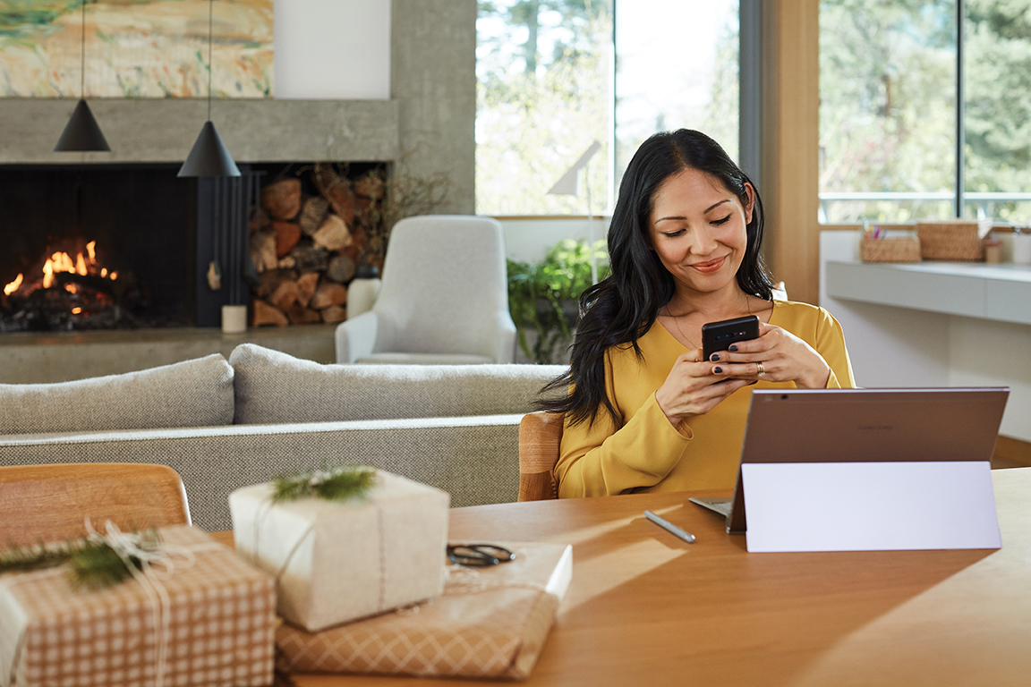 Adult female works from home on Samsung Galaxy Book 2. Family; Holiday 2019