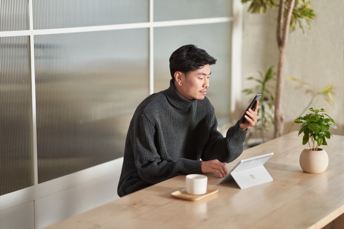 Customer using secure multi-factor authentication on a mobile phone and a tablet while working remote from a caf&eacute;
