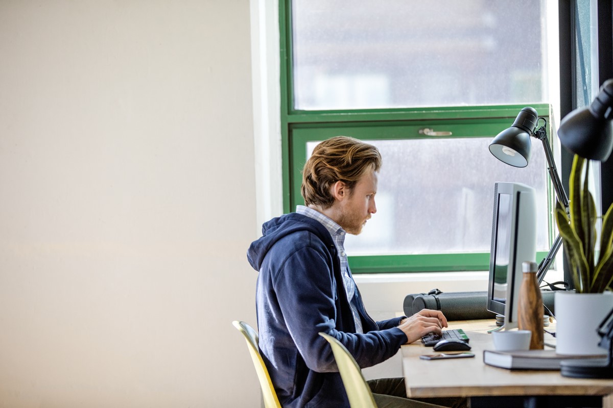 Young, small business male with All-in-one in modern workplace