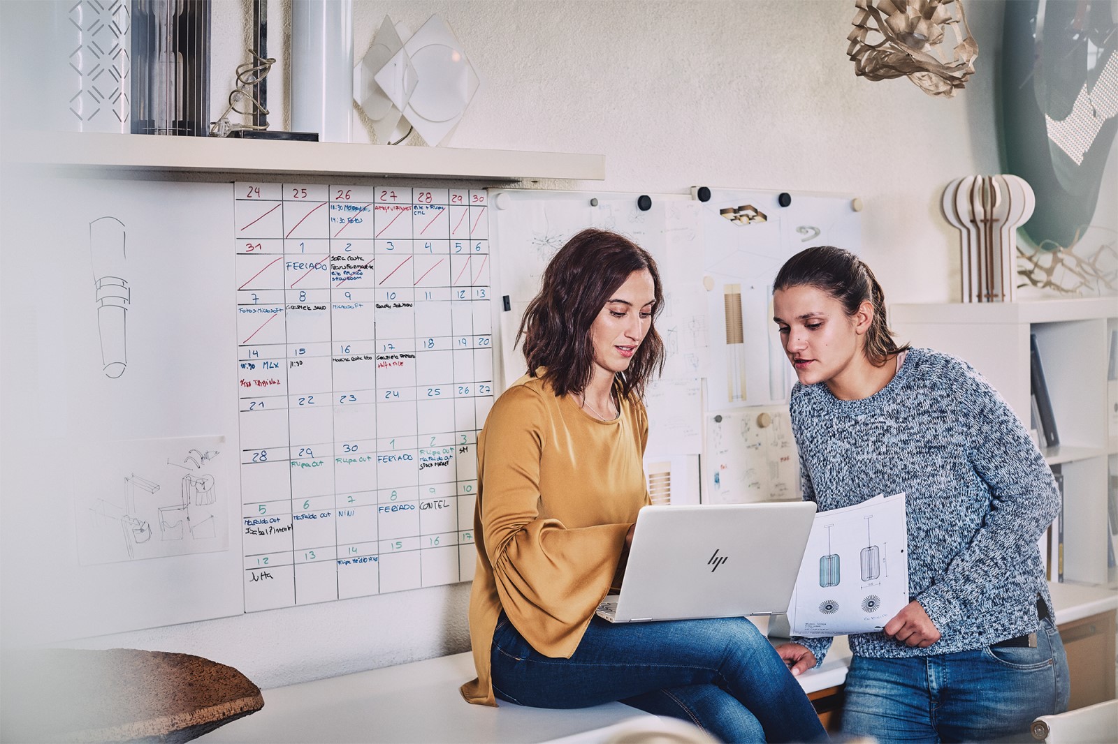 Design project manager analyzing customer experience data with a marketing team member