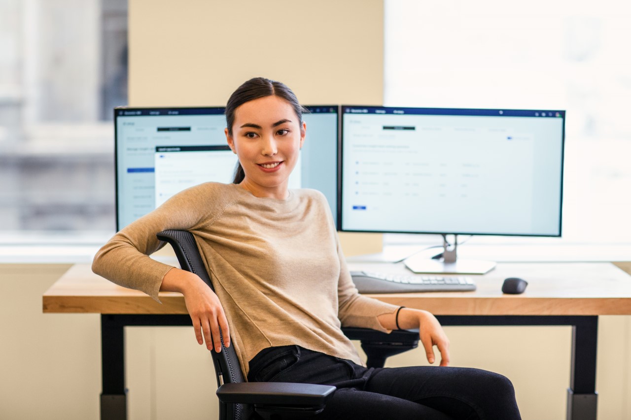 Engineer working at her desk; multi-screen workstation