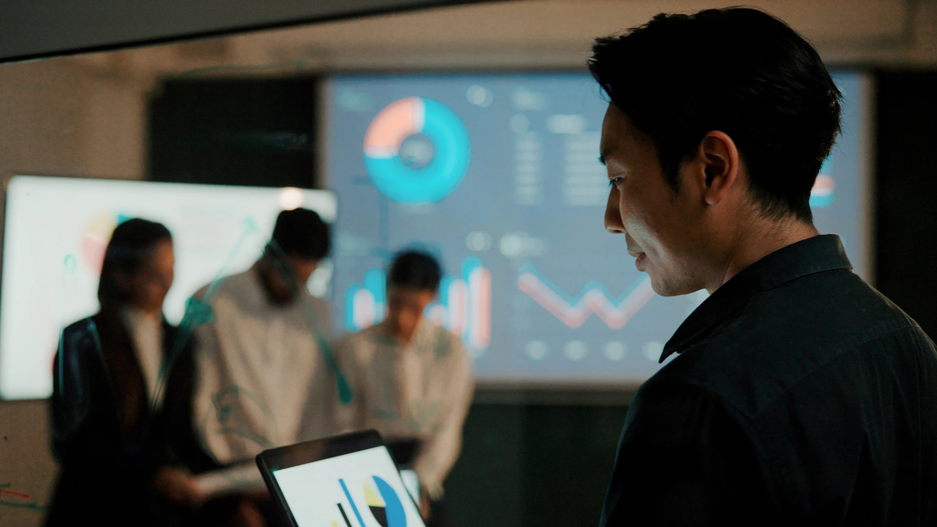 Enterprise team collaborating around analytics dashboards and business performance data to support AI-powered decision making