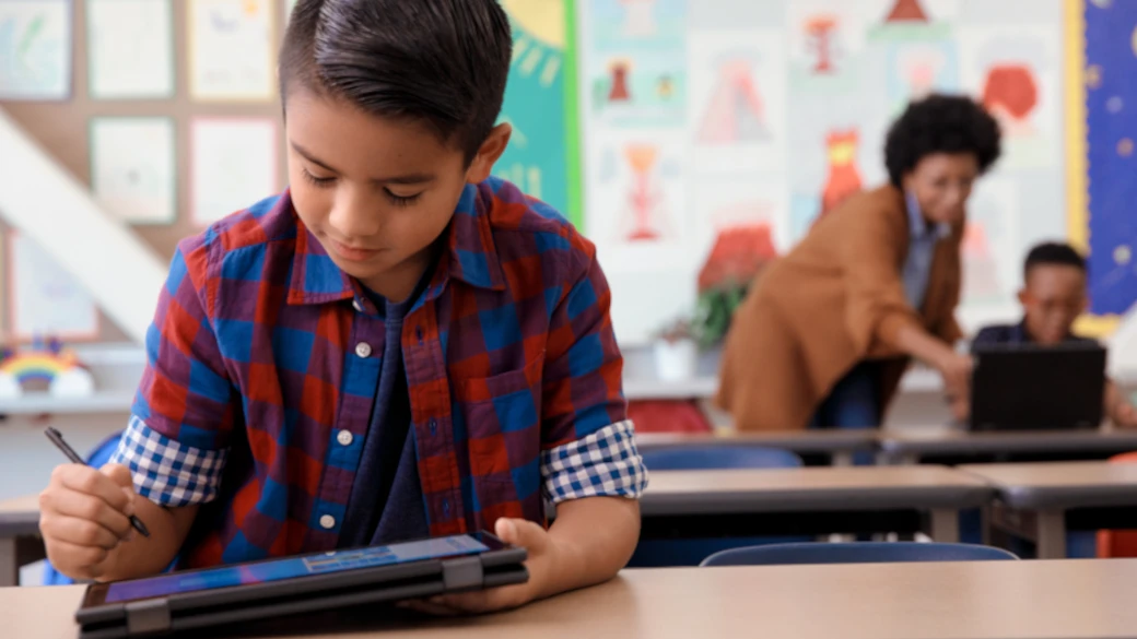 Student in a classroom working on a tablet