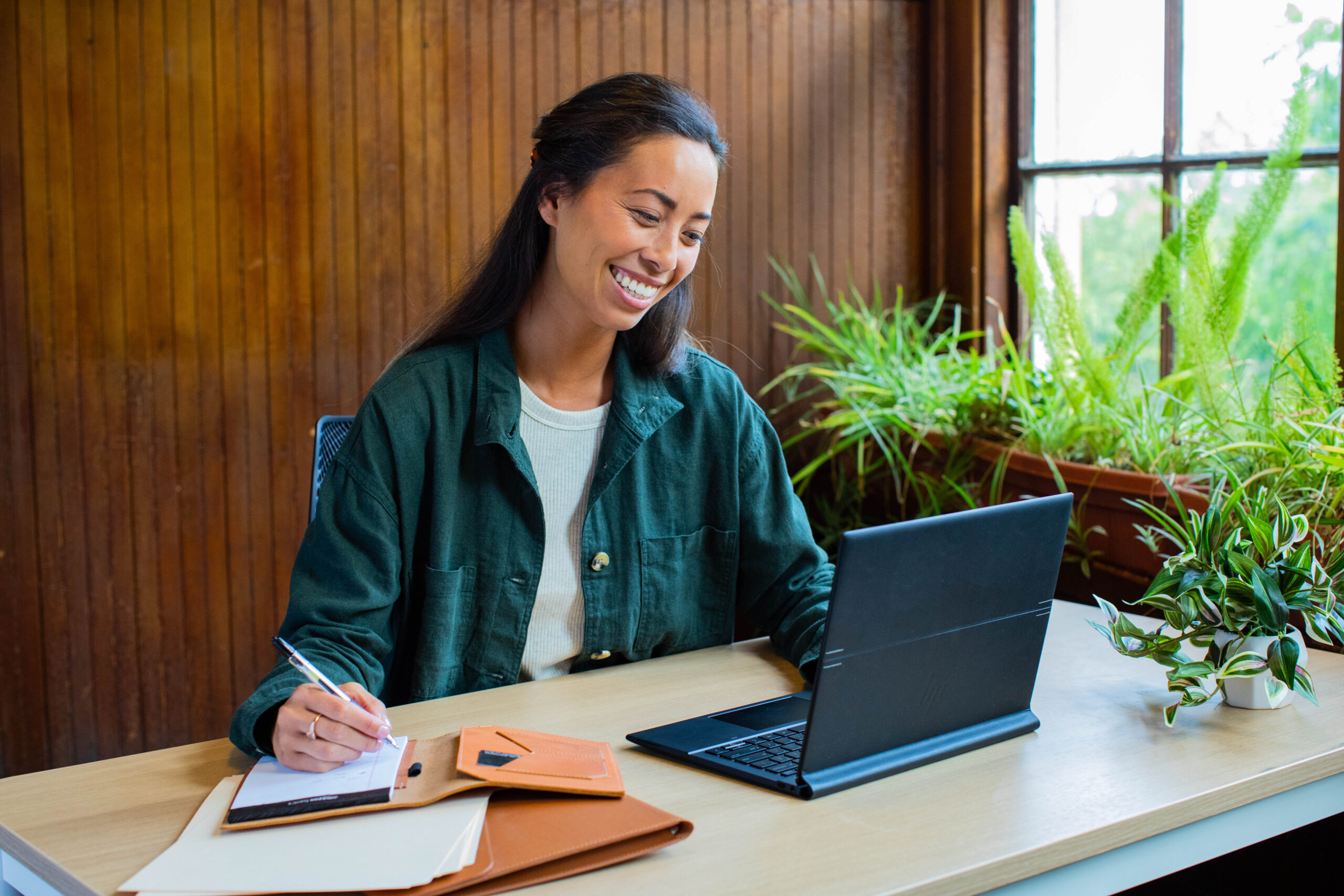 A person seated at a desk, actively working on a laptop