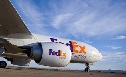A FedEx plane sits on a runway preparing for takeoff