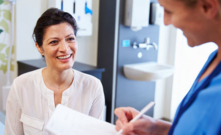 A doctor speaks with a patient and takes notes