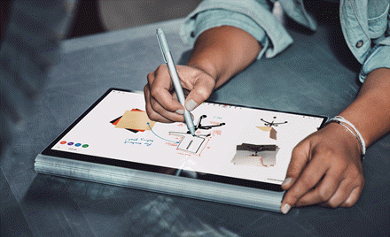 Image of a hand holding a pen and drawing on a tablet that displays Microsoft Whiteboard Preview
