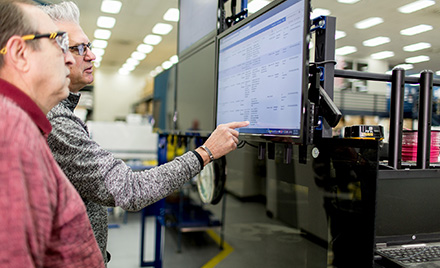 Image of two workers looking at a computer screen