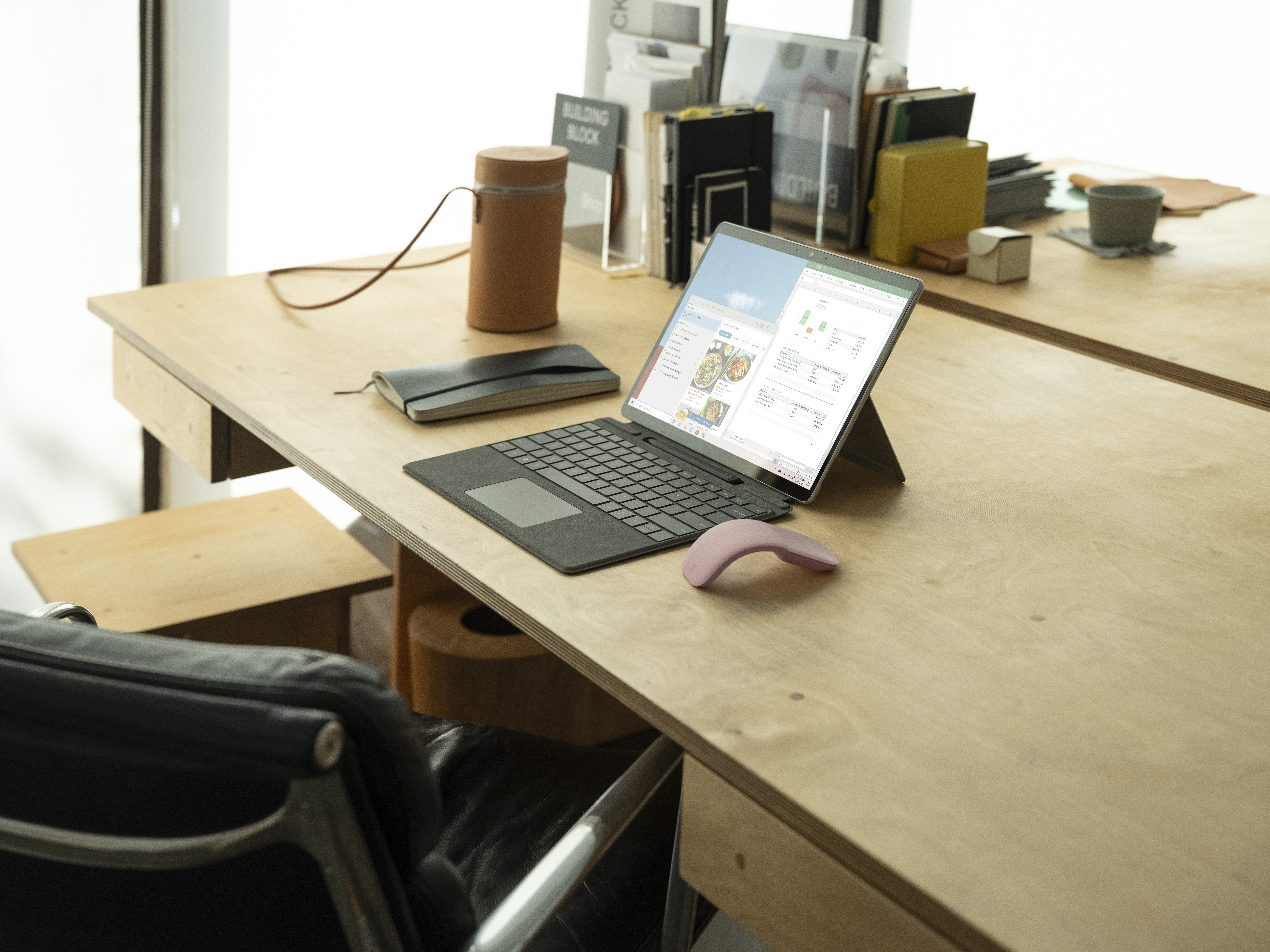 Surface Pro X and Surface Arc Mouse inside on desk with Excel and search on screen