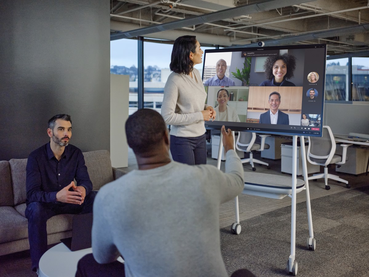 Hybrid team collaborating in modern office space and on Microsoft Teams