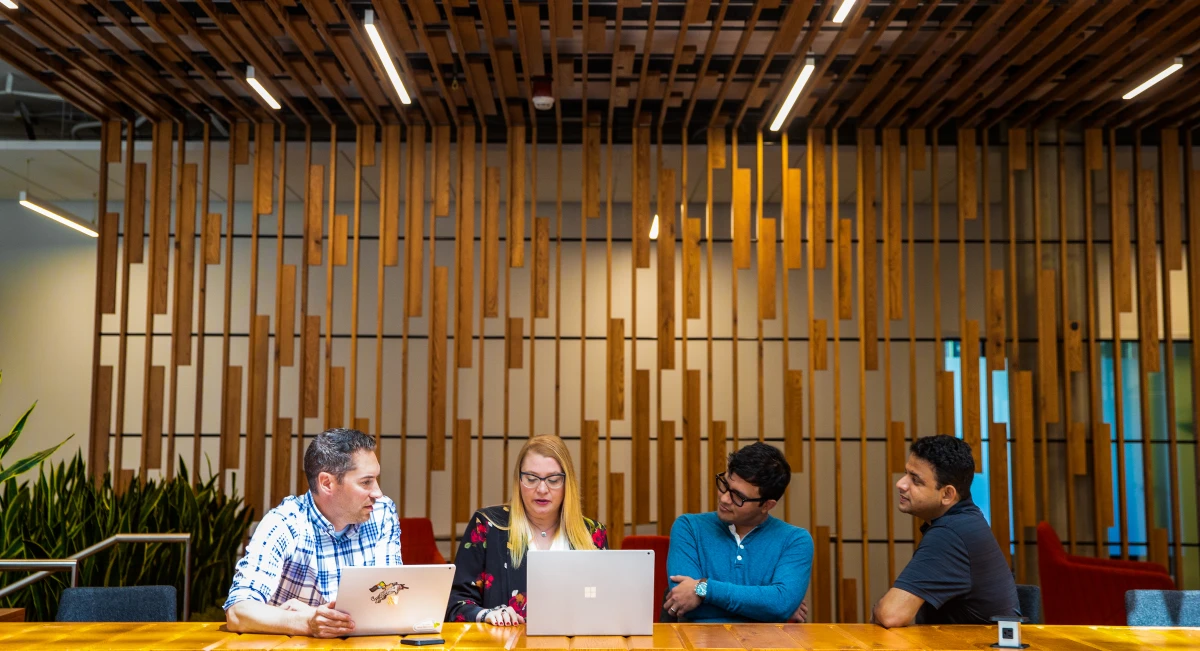 A group of tech workers hold meeting in common space of US office