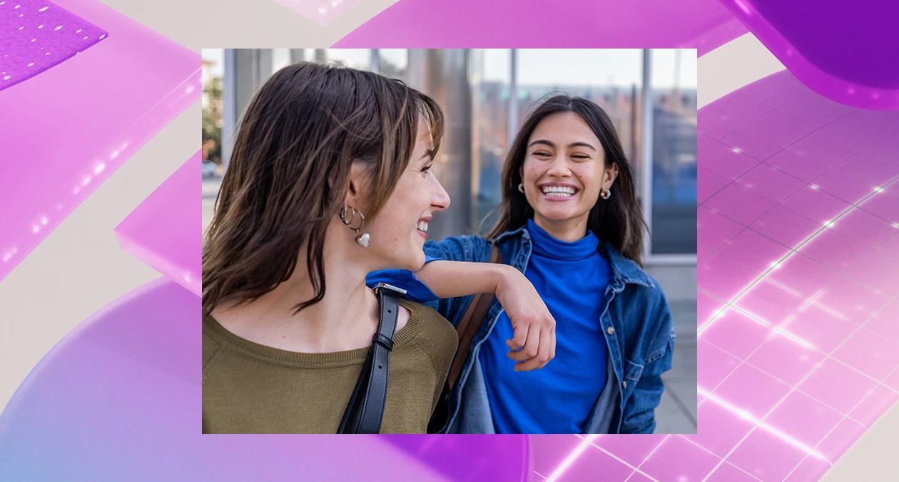 Two women smiling at each other while walking. The image is overlaid on a purple abstract background