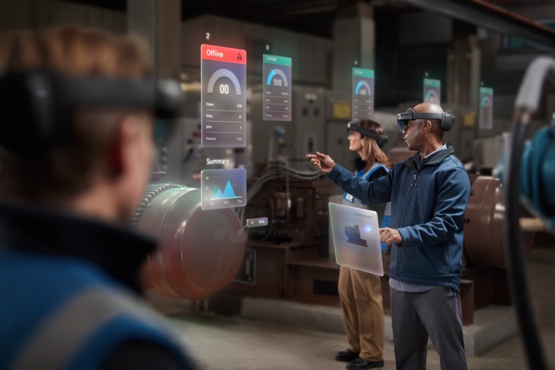 Two men and a woman collaborating using Microsoft Hololens 2 on the manufacturing floor