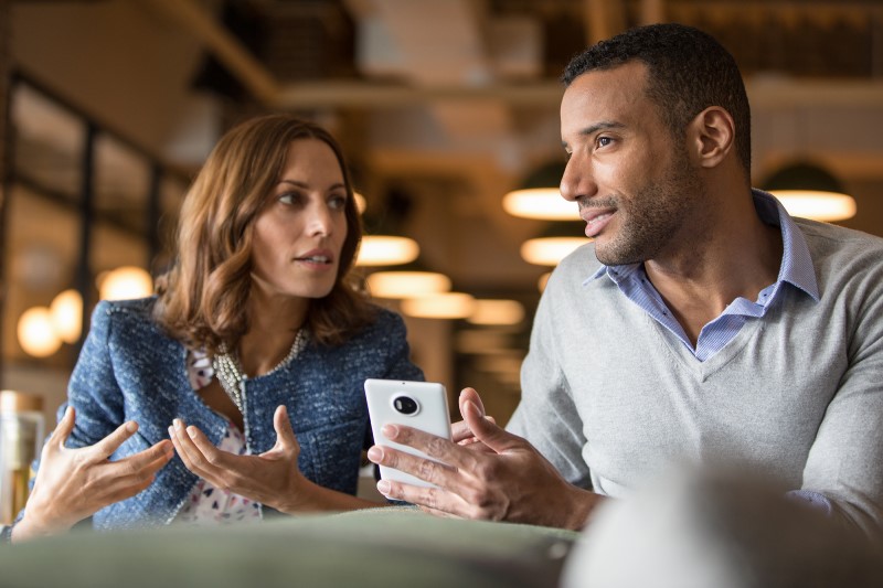 Enterprise female collaborating with male using phone