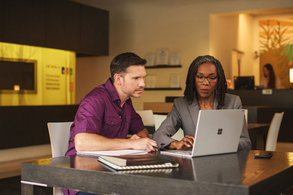 Two people working together on a laptop