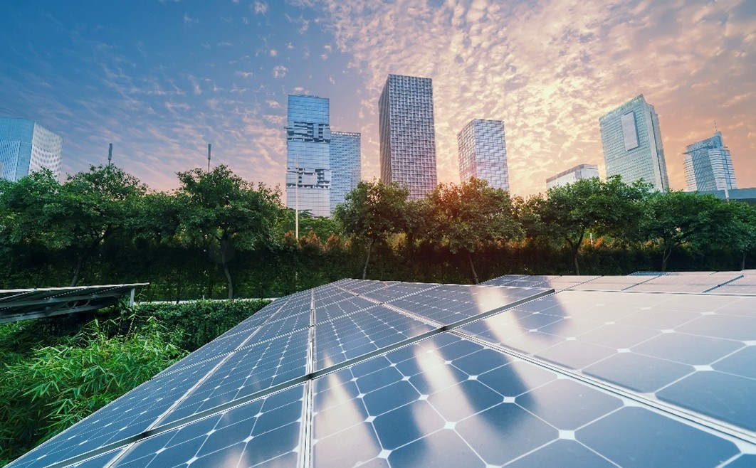 Solar panels in the foreground, city skyline in the background