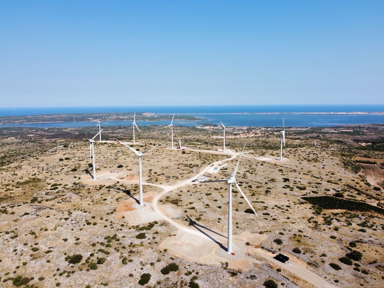A decorative image of a field with wind turbines