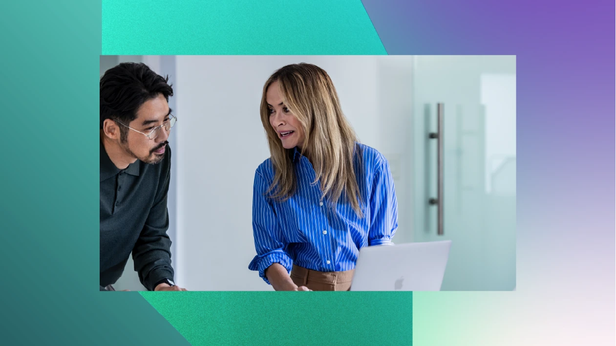 A man and woman looking at a laptop