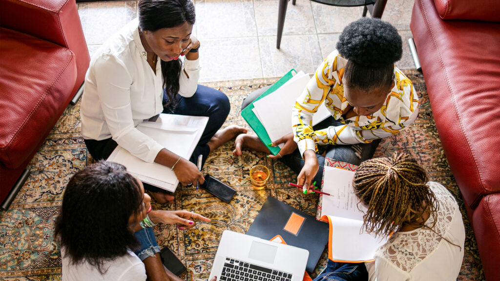 Group gathered working together on a project, seated on the floor