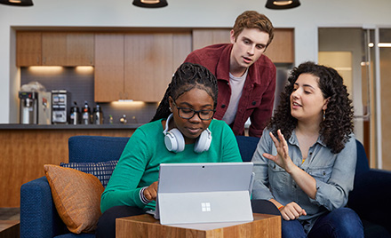 Image of students hovered over a computer