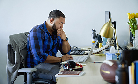 Image of a tech worker at his desk looking at a computer