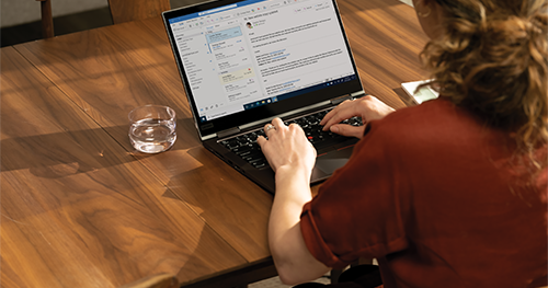 Over the shoulder photo at a dining room table with a Lenovo ThinkPad X1 Yoga