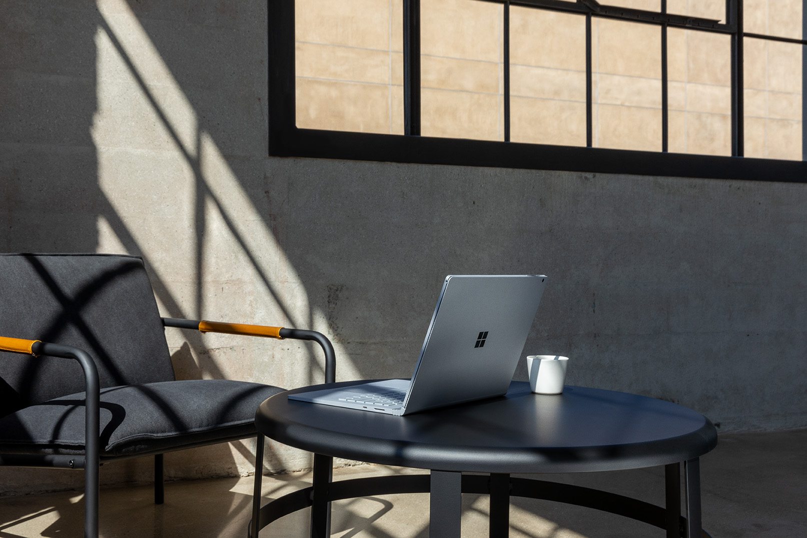 Commercial contextual lifestyle image of Surface Book 3 at desk in office alone