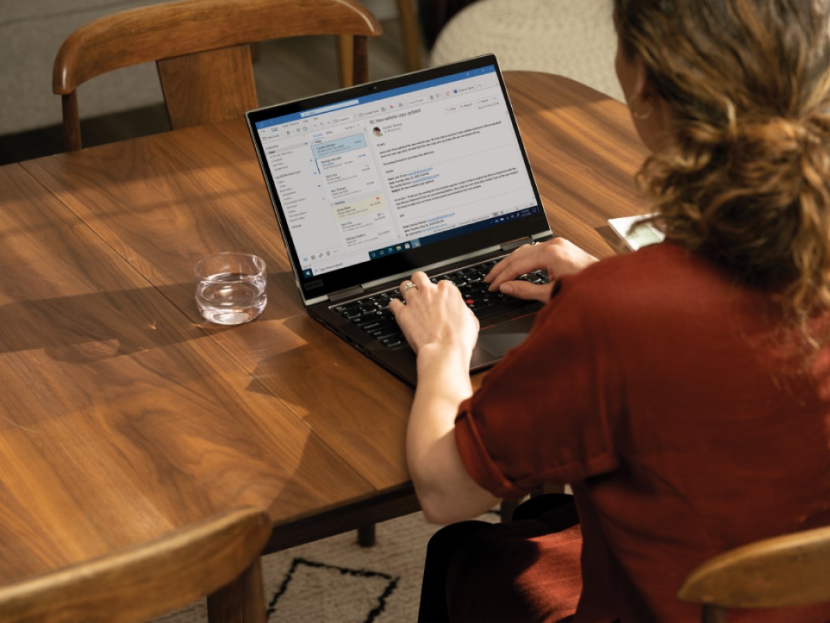 Over the shoulder photo at a dining room table with a Lenovo ThinkPad X1 Yoga. Remote Working collection
