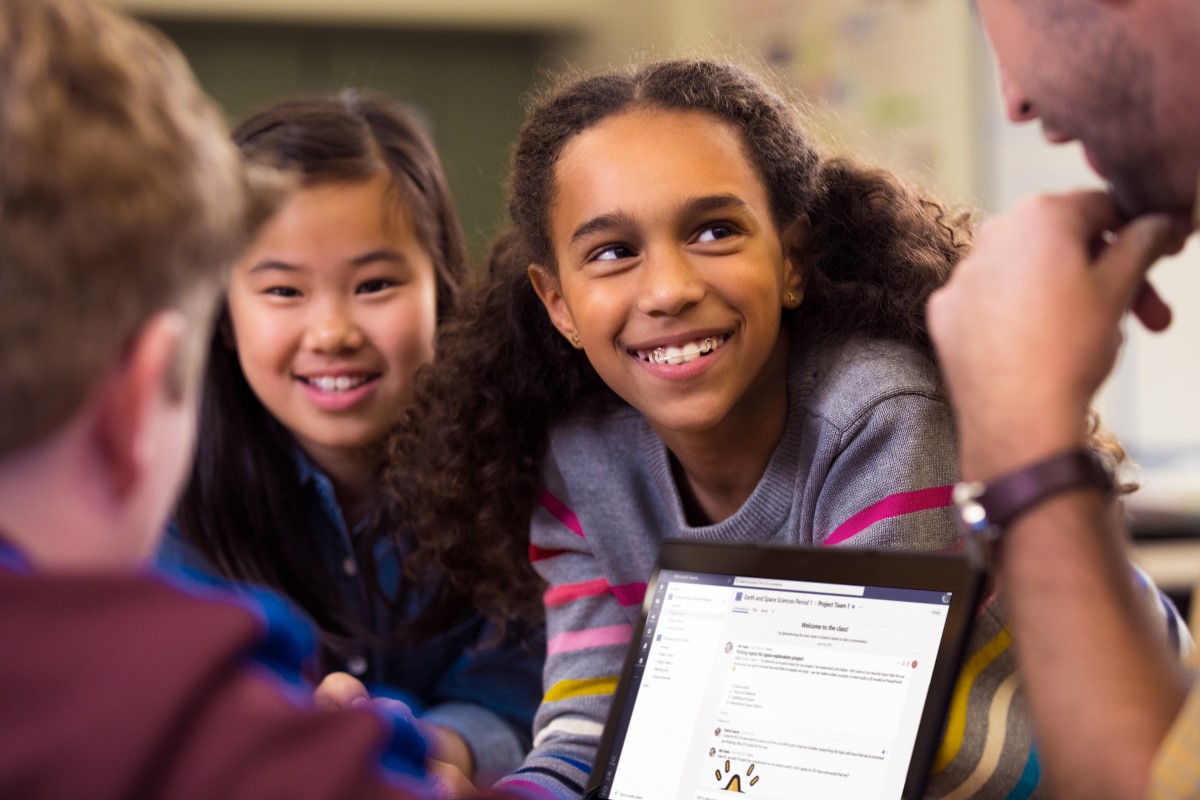 A group of students working with their teacher, with Microsoft Teams on the screen