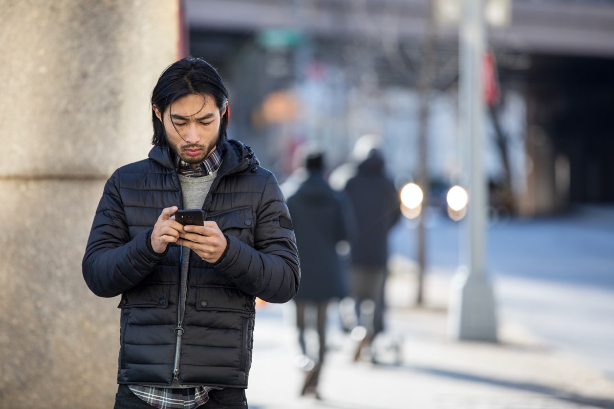 Small business male achieving outside the office (mobile) using a phone