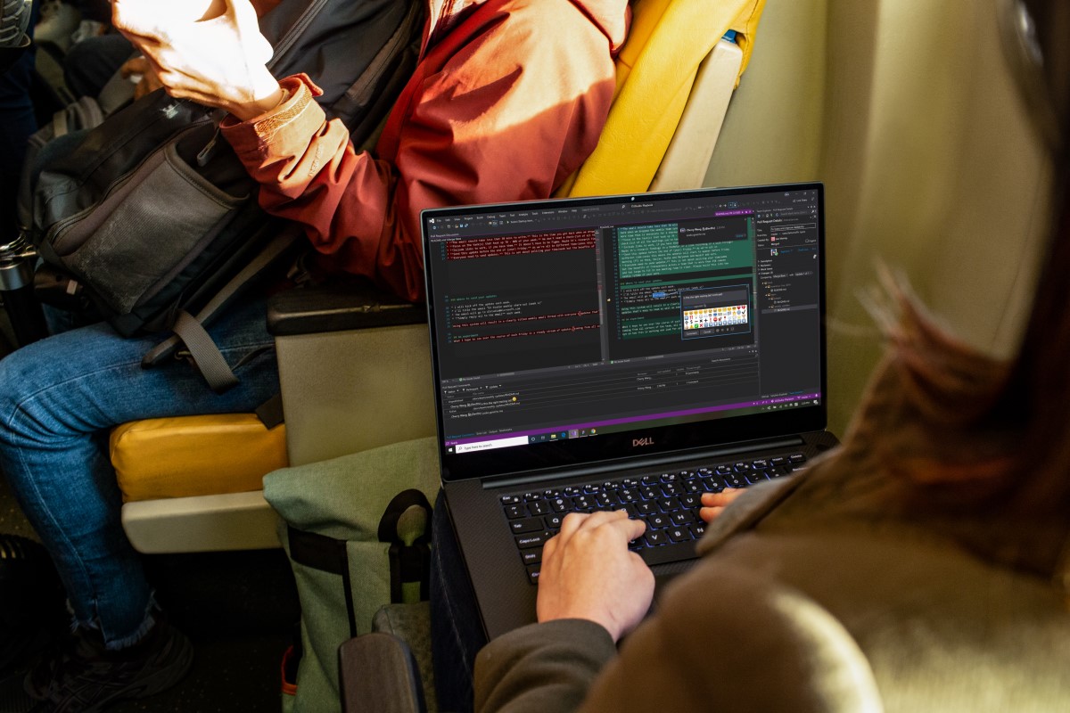Developer coding on PC laptop during commute in public transport