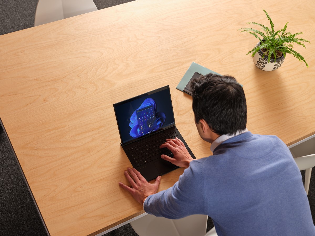 Business person calling up the Windows 11 Start Menu on laptop device