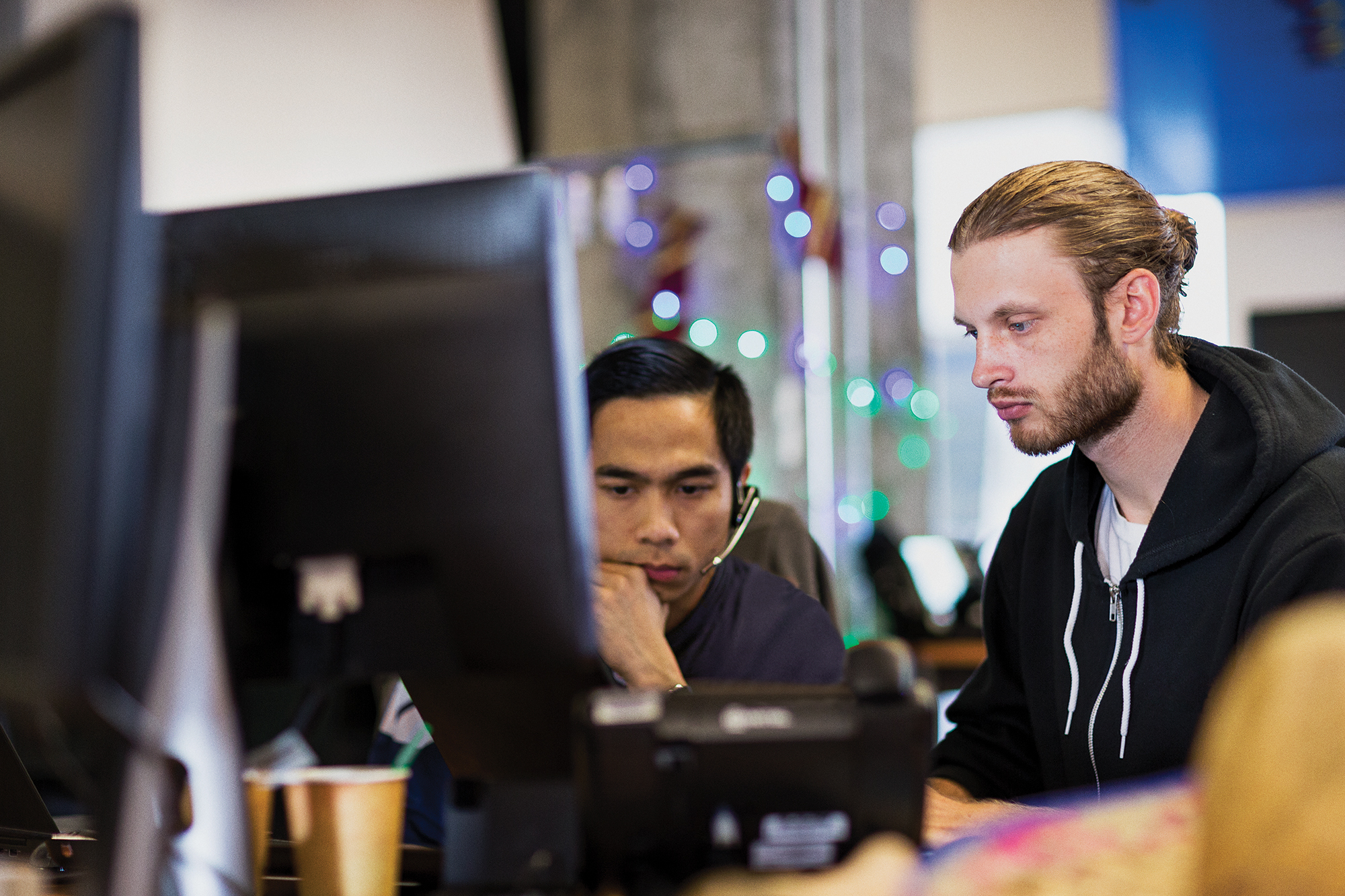 Two male engineers sitting in front of a computer screen