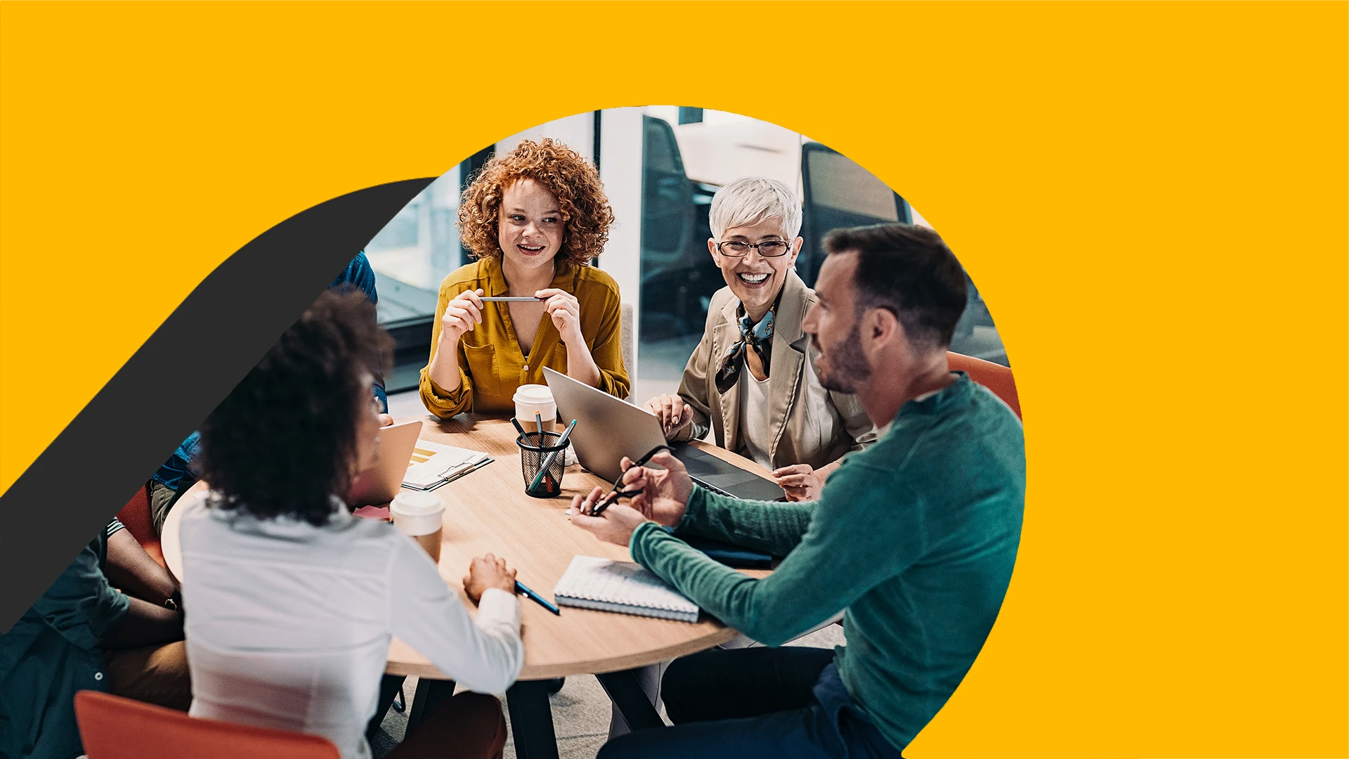 Group of business people having a meeting at a round conference table in a creative office