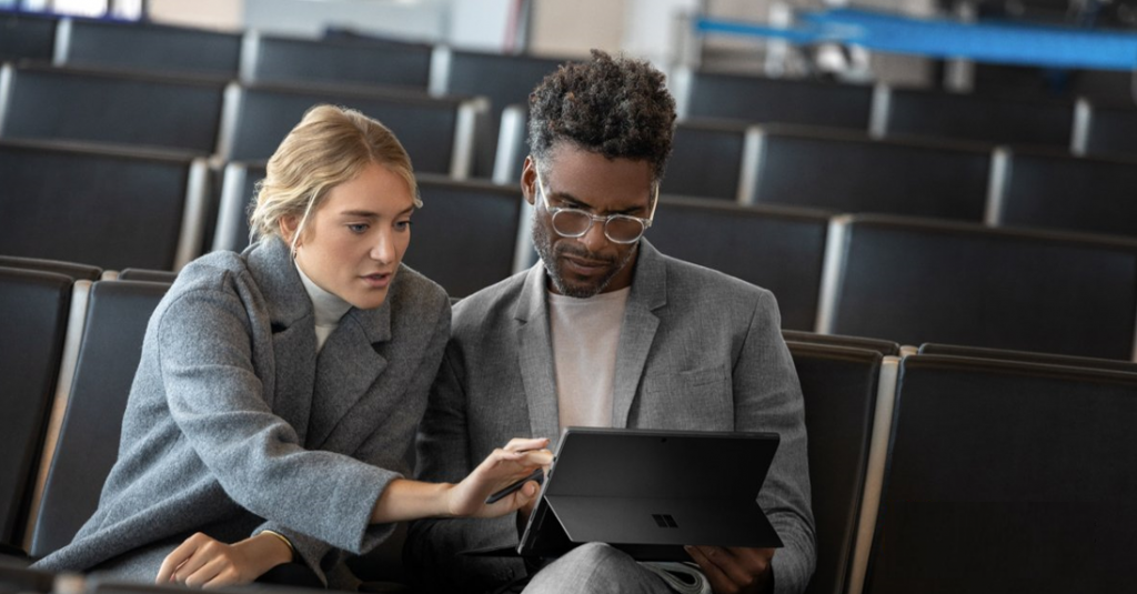 Deux personnes passant en revue le travail fait sur un ordinateur portable.