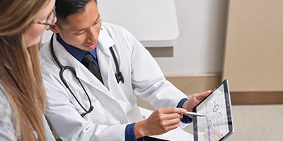 M&eacute;dico mostrando dados atrav&eacute;s do tablet